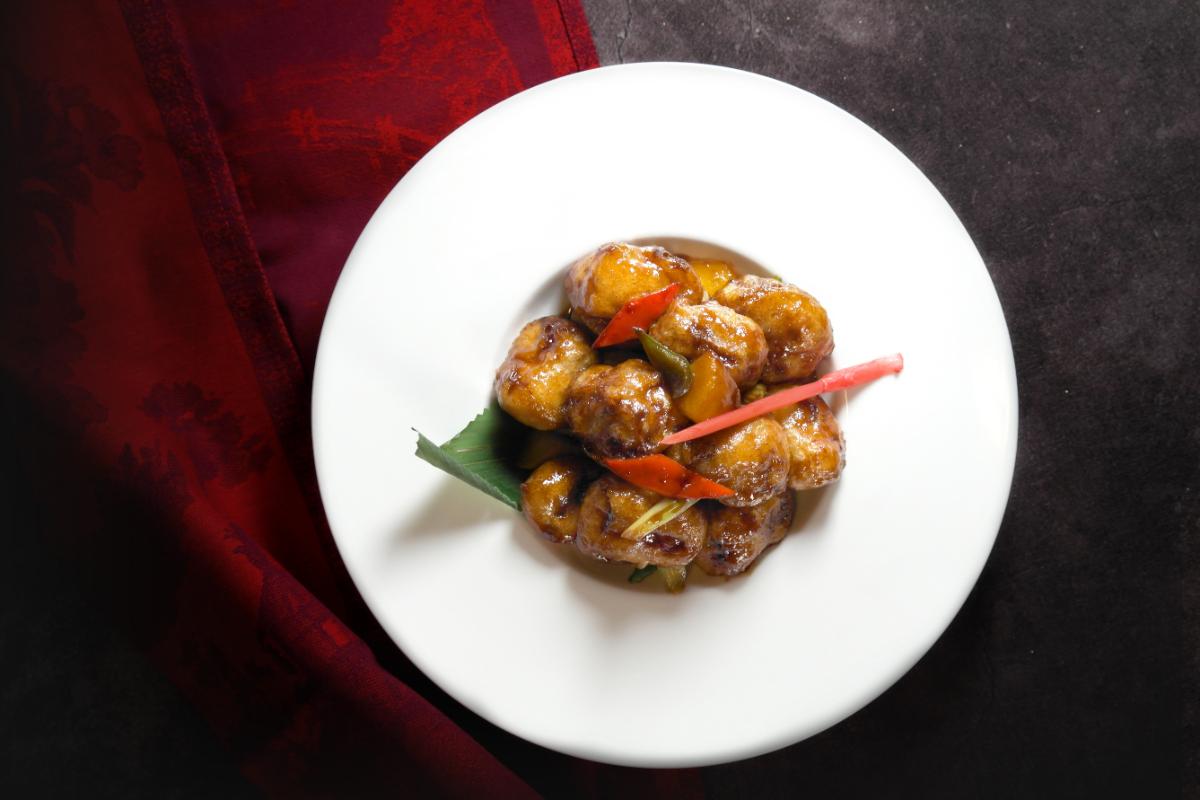 Daging Babi Renyah berisi persik yang dicelup dalam saus nanas cuka hitam